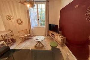 a living room with a couch and a tv at LE FIGUIER - CLIM - WIFI in Villeneuve-lès-Avignon