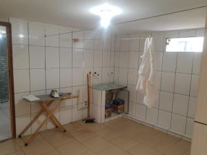 a room with white tiled walls and a table at Casa Super CONFORTÁVEL a 8min da praia do Forte in Cabo Frio