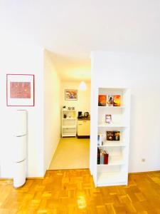 a room with a kitchen and a hallway with white shelves at HannoverMesseApartment 2 bedroom in Hannover