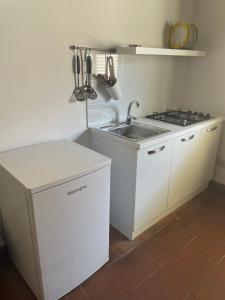 - une cuisine blanche avec évier et cuisinière dans l'établissement Terrasini 2000 Case Vacanza, à Terrasini