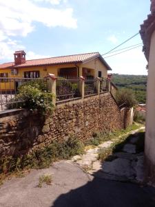 a house on the side of a stone wall at V klancu in Dekani