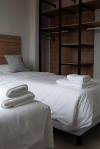 a bedroom with a white bed with towels on it at Las Cumbres Ushuaia in Ushuaia