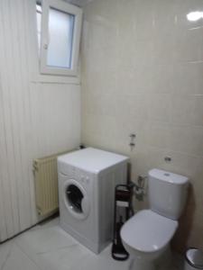 a bathroom with a washing machine and a toilet at V klancu in Dekani +7 photos