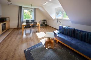 sala de estar con sofá azul y mesa en Ferienhaus Schulte - Villa Jupp und Apartment Liesl, en Olsberg