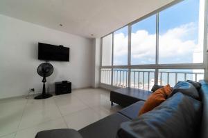 sala de estar con sofá y TV de pantalla plana en Cozy Apartment in El Laguito, en Cartagena de Indias