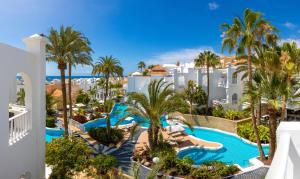 ein Luftblick auf ein Resort mit einem Pool und Palmen in der Unterkunft Lagos de Fañabé Beach Resort in Adeje