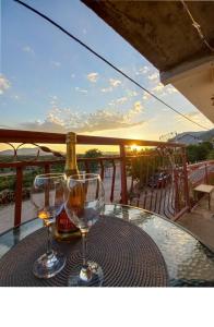 a table with two glasses and a bottle of wine at Apartman Kristina in Trebinje