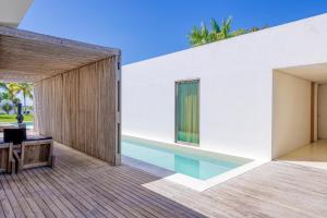 una terraza al aire libre con piscina y una casa en KA BRU Beach Boutique Hotel, en Barra Grande