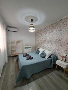 a bedroom with a blue bed with a floral wall at COLON Nerja in Nerja