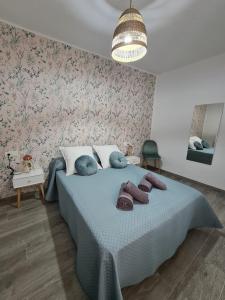 una camera da letto con un letto con una coperta blu e fiori di COLON Nerja a Nerja