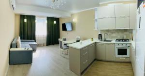 a kitchen and living room with a couch and a table at ISMAIL LUX 2 Rooms apartment CENTRE CHISINAU in Chişinău