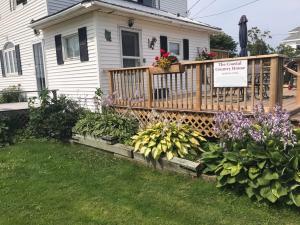 una casa con una terraza con un ramo de flores en The Coastal Country House in New Brunswick, en Cape Tormentine