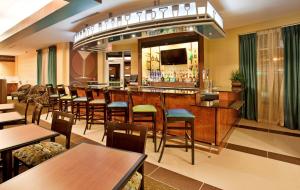 un restaurante con bar, mesas y sillas en Holiday Inn Columbia East, an IHG Hotel, en Columbia