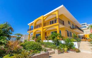 una casa amarilla con árboles y plantas en Beso del Sol, en Santa Marianita