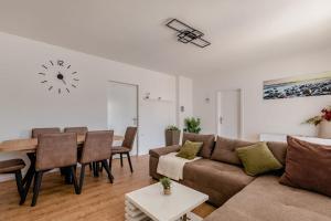 a living room with a couch and a table and a clock at Apartments by the sea Molat - 18433 in Molat