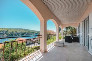 an outdoor balcony with a view of the water at Apartments by the sea Molat - 18433 in Molat