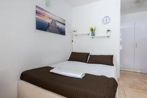 Bett in einem weißen Zimmer mit in der Unterkunft Apartments by the sea Molat - 18433 in Molat