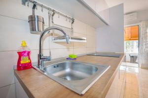a kitchen sink with a red detergent sitting on a counter at Apartments by the sea Molat - 18433 in Molat