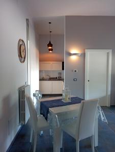 a dining room with a table and white chairs at Domus Mea in Nardò