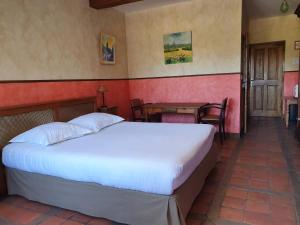 a bedroom with a bed and a table and chairs at Les Mout'Anes in Saint-Hilaire-sur-Helpe