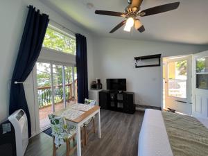 a bedroom with a bed and a table and a ceiling fan at Knotty Pine Ocean Front Suite - Adults Only in Ingonish Beach