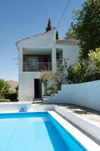 uma villa com piscina em frente a uma casa em Casa rural Balcón de Monachil em Monachil