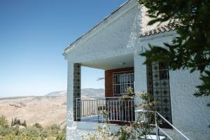 a building with a balcony with mountains in the background at Casa rural Balcón de Monachil in Monachil