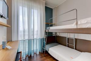 a bunk bed room with two bunk beds and a desk at BeYou Hotel Polo in Riccione