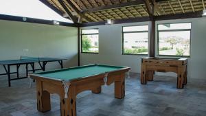 two ping pong tables in a room with windows at Carneiros Beach Resort in Praia dos Carneiros