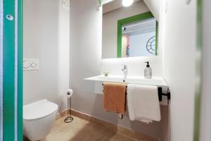 Un baño con lavabo, inodoro y espejo. en La picia, en Rovinj 37 fotos más