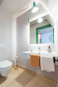 ein Badezimmer mit einem Waschbecken, einem WC und einem Spiegel in der Unterkunft La picia in Rovinj