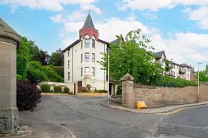 a large white building with a steeple on a street at At The Castle in Broughty Ferry