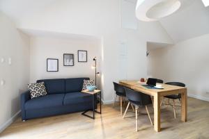 ein Wohnzimmer mit einem blauen Sofa und einem Tisch in der Unterkunft Das schiefe Haus Wohnung Odenwald in Heppenheim an der Bergstrasse