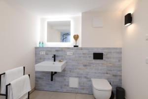Un baño con lavabo, inodoro y espejo. en Das schiefe Haus Wohnung Odenwald, en Heppenheim an der Bergstrasse