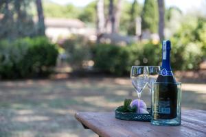uma garrafa de vinho e um copo sobre uma mesa em Dolce Far Niente Apartment with pool & parking em Passignano sul Trasimeno