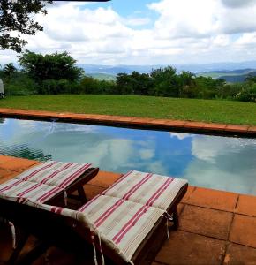 two lounge chairs sitting next to a swimming pool at Wild Fig Guesthouse in White River