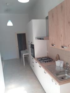 a white kitchen with a sink and a stove at Independence house 71 in Bari