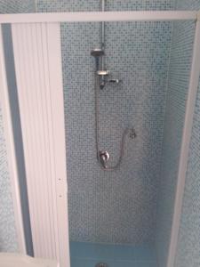 a shower in a bathroom with blue tiles at Independence house 71 in Bari +8 photos