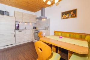 uma cozinha com uma mesa de madeira e cadeiras amarelas em Ferienwohnung Reiter em Sankt Jakob in Haus