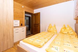una camera da letto con un grande letto con lenzuola gialle di Ferienwohnung Reiter a Sankt Jakob in Haus