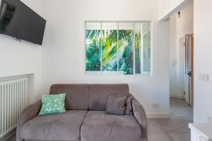 un soggiorno con divano marrone e finestra di CasaBaltó a Sanremo