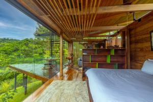 a bedroom with a bed and a large glass window at Ecolirios Boutique Hotel and Spa in Guácimo