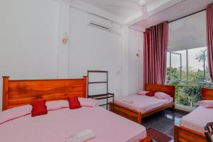 1 dormitorio con 2 camas y ventana en DELIGHT REICH HOTEL en Peradeniya