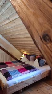uma cama num sótão com tecto em madeira em Maurushaus em Füssen