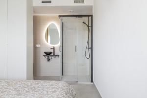 uma casa de banho branca com um chuveiro e uma cama em Sunset Beach II em Santa Pola