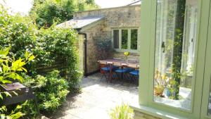 a patio with a table and chairs outside a window at Lovely property in the heart of Somerset, sleeps 9 in Shepton Mallet