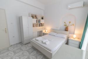 a white bedroom with a bed and two night stands at Evangelia's Mansion in Naxos Chora