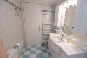 a white bathroom with a sink and a mirror at Evangelia's Mansion in Naxos Chora