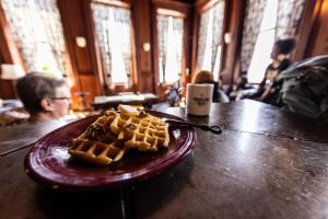 um prato de waffles numa mesa num restaurante em Traveler's Rest Hotel em Pittsburgh