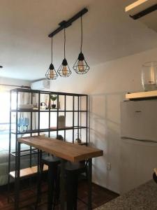 eine Küche mit einem Holztisch und einigen Lampen in der Unterkunft Comodo monoambiente bien ubicado en Cordon in Montevideo